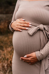 Pregnant women is touching her tummy