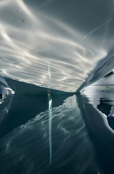 the stern of the sailboat and the rudder feather in the azure water, sun reflections are on glossy board of moored sail boat, Monaco, Monte-Carlo, tranquillity in port Hercules at sunny day