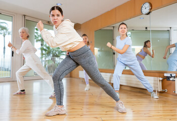 Obraz premium Group of different ages women enjoying active dance movement in modern studio