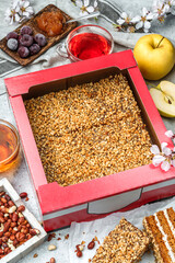 Delicious honey biscuit cake with cream, apples, cherries and peanuts in paper box for delivery on...