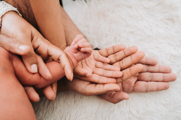 Family hands are stacking hands under the baby's hand