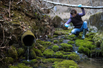 Adult Woman Environmental Conservation Volunteer Collecting Samples of Water Before Reaching a...