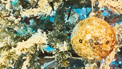 Defocused Christmas tree ornaments with teal orange toning.Xmas decor. Christmas decorations background. Golden bauble on fir tree. Soft focus. film grain pixel texture. Defocused.