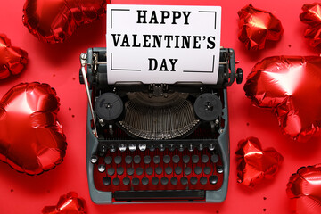 Vintage typewriter with letter and heart shaped balloons on red background. Valentines Day...