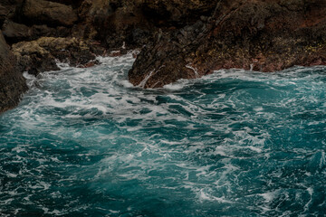 Waves breaking on the rocky shore of the island of Madeira