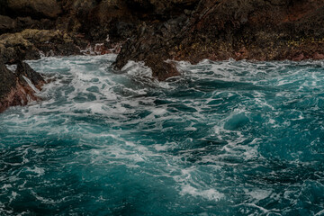 Waves breaking on the rocky shore of the island of Madeira