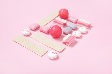 Many different tasty chewing gums on pink background