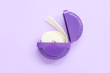 Chewing gum in plastic box on lilac background