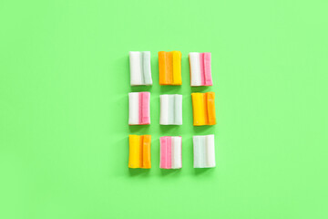 Fototapeta na wymiar Tasty chewing gums on green background