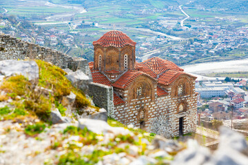 View of Byzantine style building of medieval Holy Trinity Church on green flowering slope of hill...