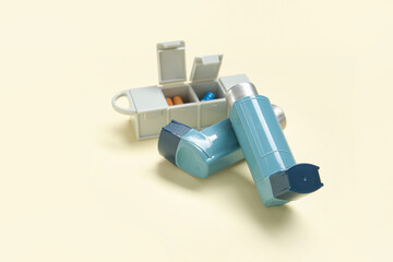 Asthma inhalers with pills case on yellow background