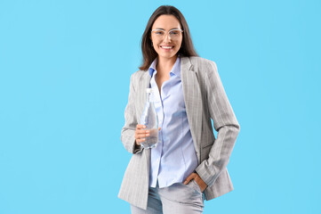 Young businesswoman with bottle of water on color background