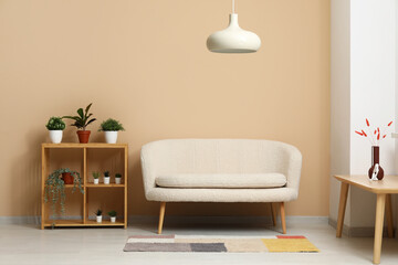 Modern living room interior with cozy white sofa, shelving unit and lamp