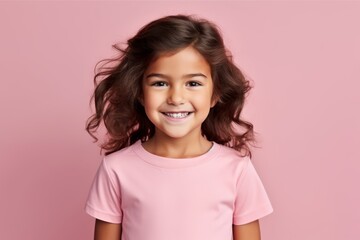 Portrait of a smiling little girl with long curly hair over pink background