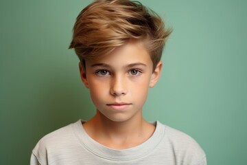 Portrait of a little boy with blond hair on a green background - obrazy, fototapety, plakaty