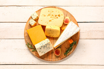 Plate with tasty cheese on white wooden background