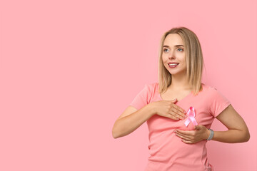 Young woman with ribbon on pink background.  Breast cancer awareness concept