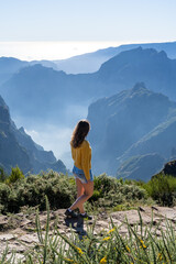 Female tourist walks along trail and enjoys the picturesque view from the summit of a volcanic...