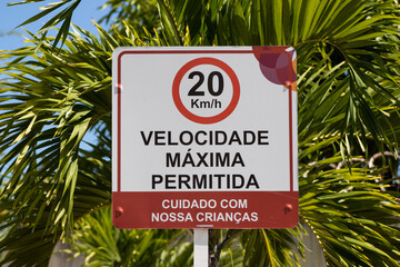 Placa informando o limite máximo de velocidade em um condomínio residencial. 