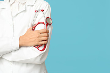 Female doctor with red stethoscope on blue background, closeup
