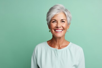 Portrait of a happy senior woman smiling at the camera over green background