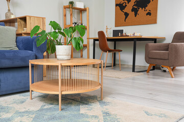 Interior of modern room with comfortable sofa, coffee table and houseplant