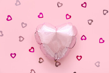 Composition with heart shaped foil balloon and confetti on pink background. Valentine's Day...