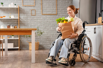 Young redhead woman in wheelchair with paper bag of healthy food at home - obrazy, fototapety, plakaty