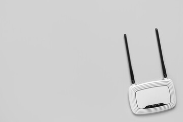 Modern wi-fi router on grey background