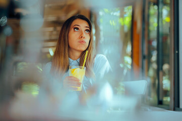 Bored Woman Waiting Alone in a Restaurant with lemonade Drink. Unhappy girlfriend being stood up on...