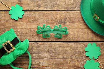 Plastic eyeglasses with leprechaun hats and paper clovers on wooden background. St. Patrick's Day celebration
