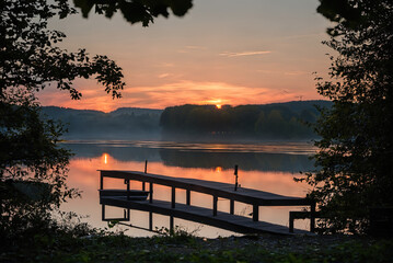 Naklejka premium Beautiful lakeside and dock wooden boats at early morning sunrise