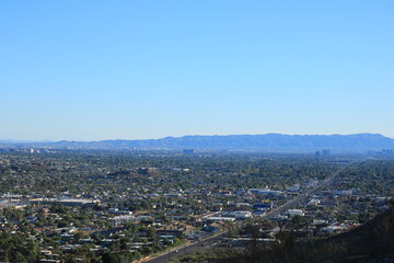 Late afternoon bluish haze over Arizona Capital City of Phoenix downtown under cloudless sky as seen from North Mountain Park toward South mountains