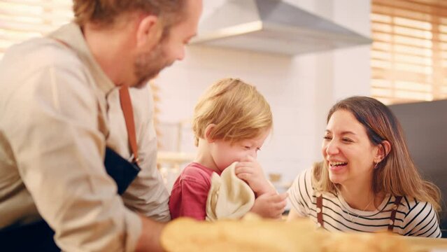 Caucasian attractive couple baking bakery with son in kitchen at home. 