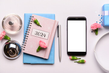 Composition with modern mobile phone, notebooks, perfume and flowers on white background