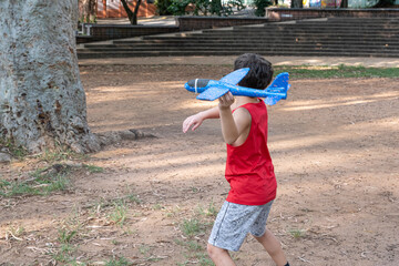 10 year old Brazilian child playing with his Styrofoam plane on a sunny afternoon_5.