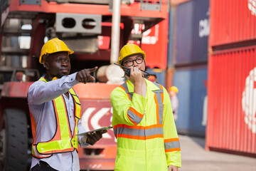 Group of diverse male container yard worker working and checking container boxes at commercial dock...
