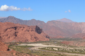 View of an old canyon, with red rocks (iron oxide), with a river in the base, Salta province, Argentina