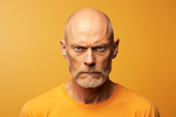 Portrait of a senior man with wrinkles on his face on a yellow background