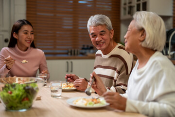 Asian lovely family having dinner, enjoying evening party in house. 