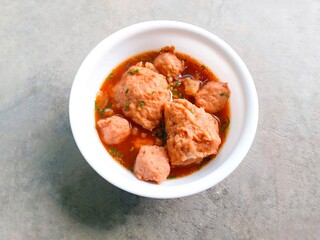 bakso, meatballs, traditional Indonesian food. Meatball soup with crackers. meatballs stuffed with quail eggs without noodles or vermicelli served in a bowl on a gray background.