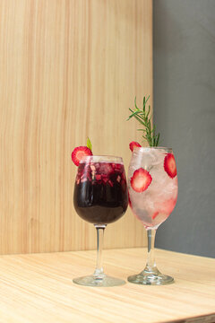 Imagen vertical de dos copas una con clericot y otra con mojito de frutos rojos 