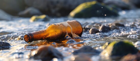 Pollution of the environment: beer bottle in water.