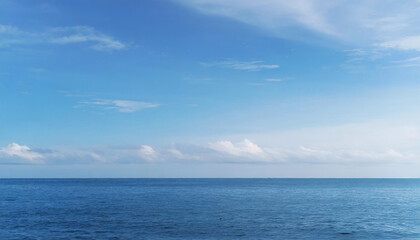 Tranquil Seascape under a Clear Blue Sky with Fluffy Clouds on a Sunny Summer Day
