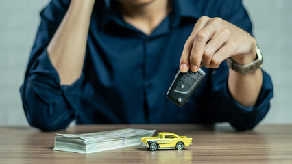 Closeup hand giving a car key and money for loan credit financial and rental. car loan concept,...