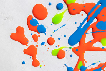 Abstract background riot of colors, spilled nail polish of bright colors: orange, blue, yellow on a white background