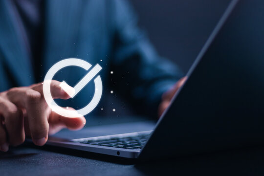 Businessman use laptop with virtual correct mark to approve document for service guarantee, business process, quality assurance management, certification.