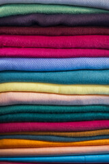 Stack of colorful new apparel up for sale in the market.