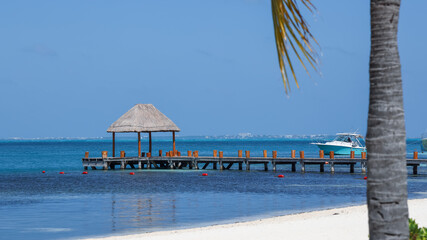 Small hut on a wooden pier at Cancun beach.