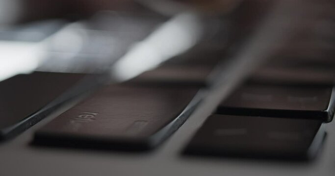Extreme Close-up of Finger Hitting "Return" Key on Laptop Keyboard